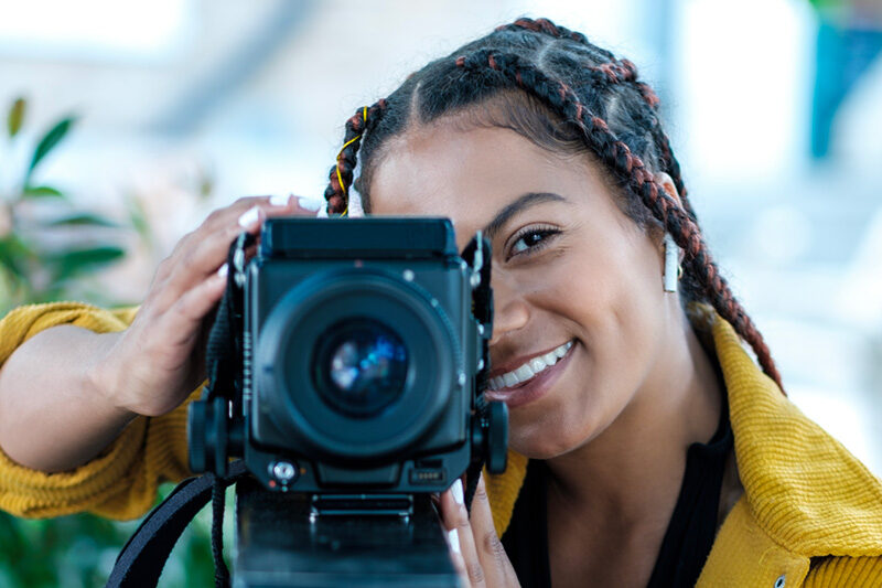 Photo of young woman using a camera